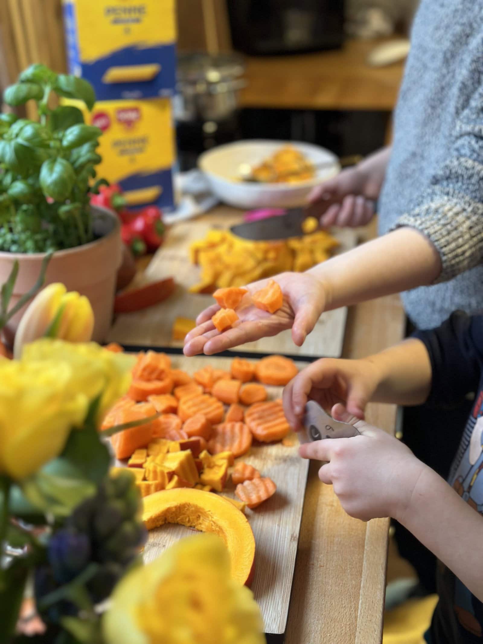 Glutenfreier Familienalltag – Kinder helfen beim Gemüseschneiden Kinderhände schneiden frisches Gemüse in der Küche – glutenfreier Familienalltag
