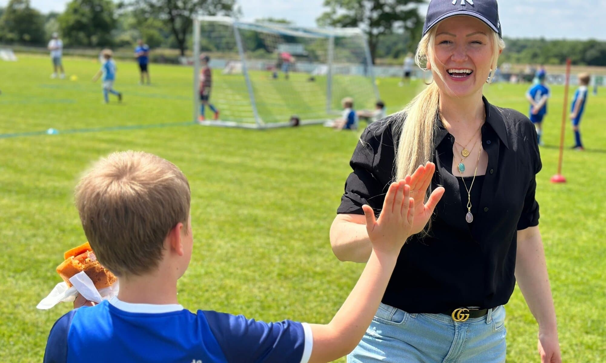 Glutenfrei grillen mit Kind – High Five beim Grillmoment Mutter und Sohn beim glutenfreien Grillen – High Five mit Grillwurst im glutenfreien Brötchen