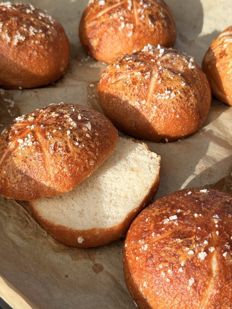 Glutenfreie Laugenbrötchen, frisch gebacken und aufgeschnitten, mit fluffiger Krume bei natürlichem Licht
