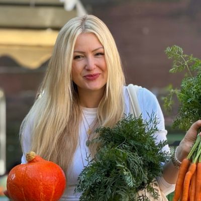 Aurélie auf dem Wochenmarkt in Freiburg Aurélie steht auf dem Wochenmarkt am Freiburger Münster und hält frisches Gemüse wie Karotten und Kürbis in den Händen