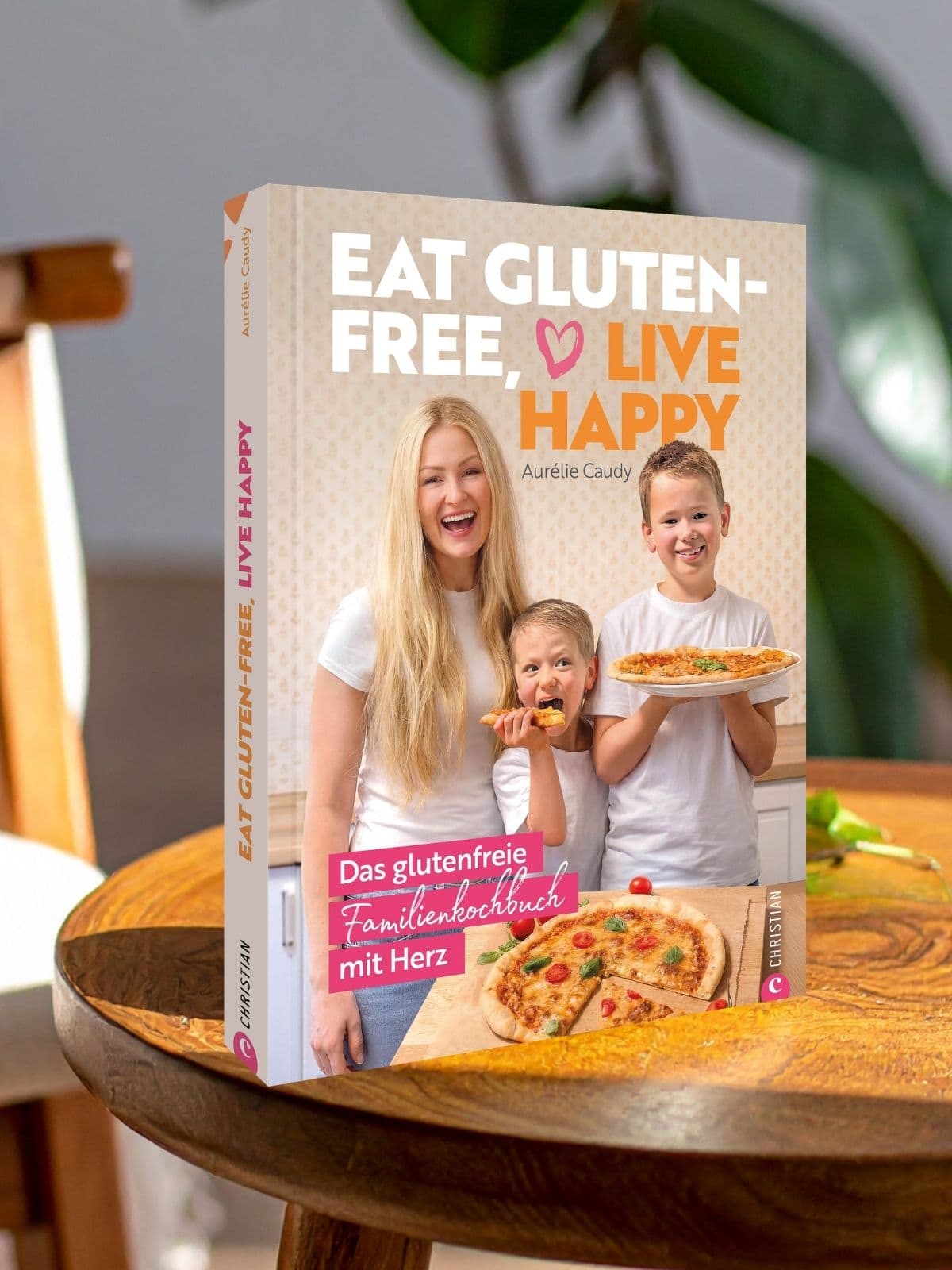 Eat Gluten Free, Live Happy – Das glutenfreie Familienkochbuch Mockup des Buchs „Eat Gluten Free, Live Happy“ auf einem Tisch mit unscharfem Hintergrund