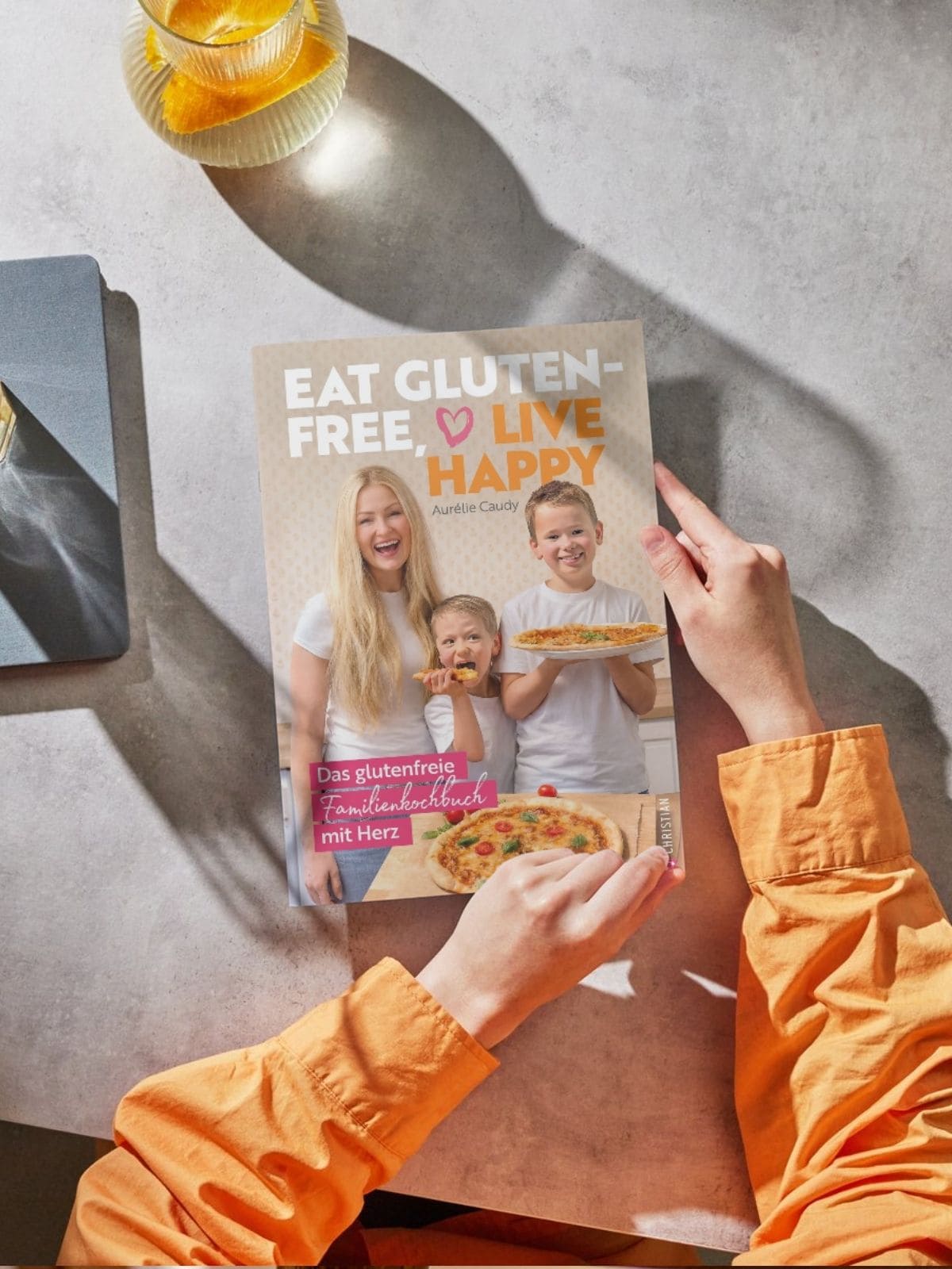 Glutenfreies Kochbuch im Alltag – entspannt glutenfrei leben Glutenfreies Kochbuch in Händen auf Küchentisch bei natürlichem Licht